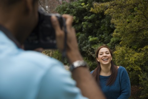 Man taking picture of smiling girlfriend