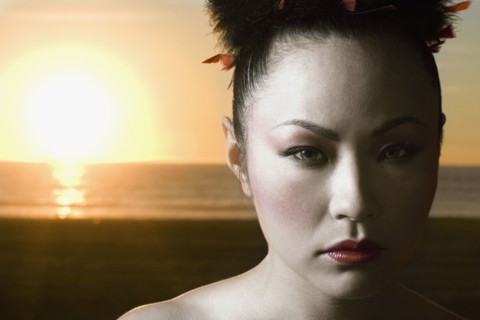 Asian woman in front of sunset