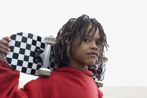 Mixed Race boy holding skateboard