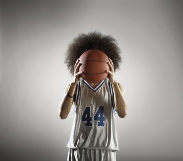 Mixed race basketball player holding basketball