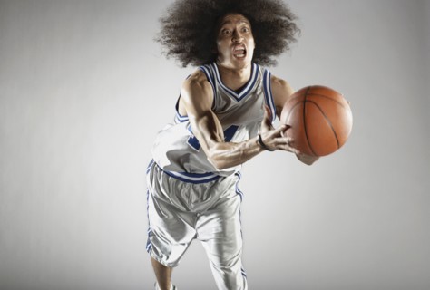 Mixed race basketball player holding basketball