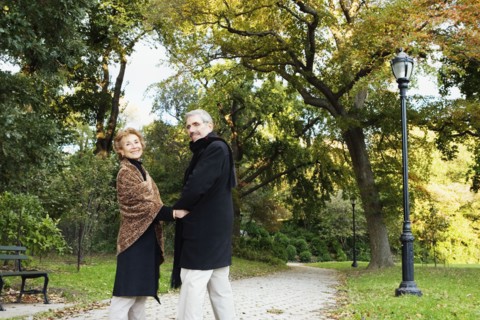 Senior couple walking and holding hands in park