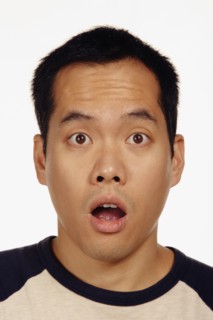 Close up studio shot of Asian man looking surprised