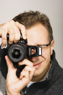 Close up studio shot of man using camera