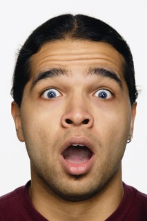 Close up studio shot of Hispanic man looking surprised