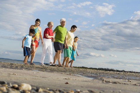 Surface shot of Hispanic family walking on beach