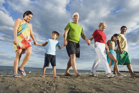 Low angle view of Hispanic family holding hands at beach