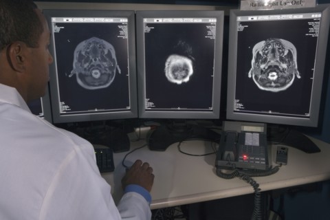 Rear view of African male doctor reviewing at brain scans