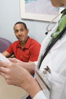 African man talking to doctor in waiting room