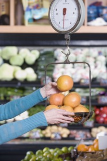 Woman weighing fruit at grocery store