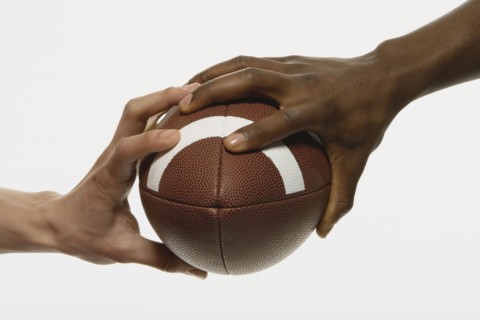 Multi-ethnic men holding football