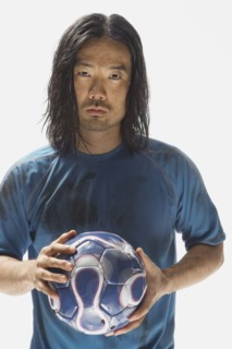 Asian male soccer player holding ball