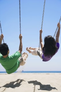 Asian couple swinging at beach