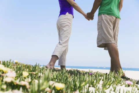 Asian couple holding hands at beach