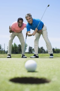 Multi-ethnic men looking at golf ball