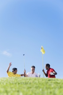 Multi-ethnic men cheering on golf course