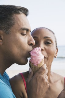 Multi-ethnic couple eating ice cream cone