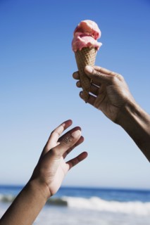 African girl reaching for ice cream cone