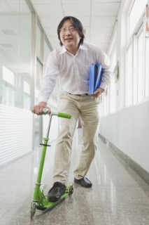 Chinese man riding scooter in corridor