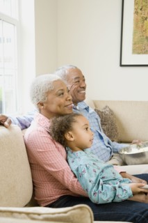 African grandparents with granddaughter in living room
