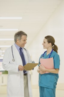 Doctor talking to nurse in hospital hallway