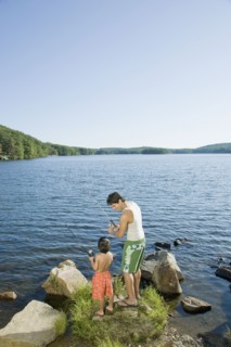 Mixed race father and son fishing in lake