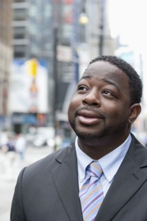 Black businessman smiling on urban street