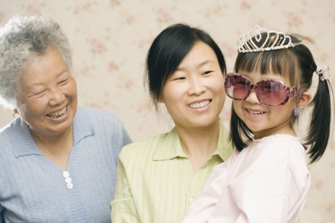 Mother and grandmother smiling at girl in princess costume