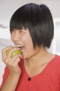 Chinese woman biting apple