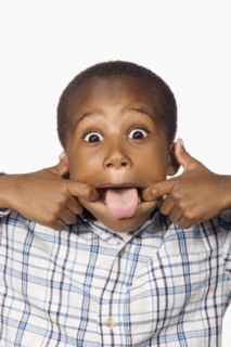 Mixed race boy making a face with tongue out