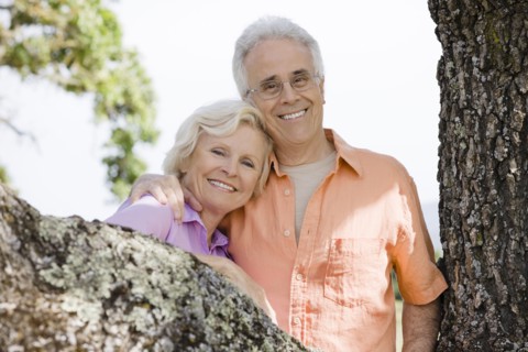Caucasian couple posing near tree