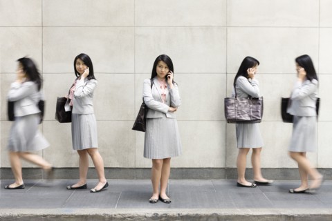 Multiple-exposure of Chinese businesswoman talking on cell phone