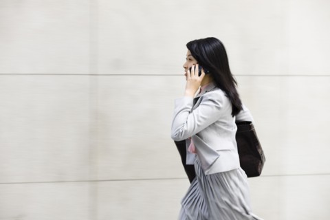 Chinese businesswoman walking and talking on cell phone