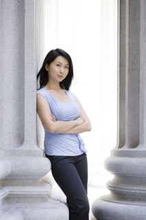 Chinese businesswoman leaning against stone pillar