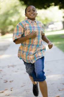 Mixed race boy running on sidewalk