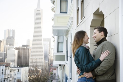 Caucasian couple hugging in city