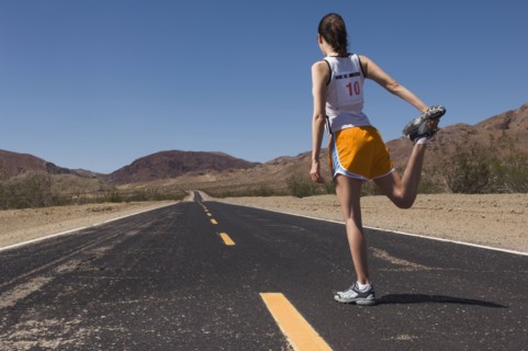 Mixed Race female runner stretching