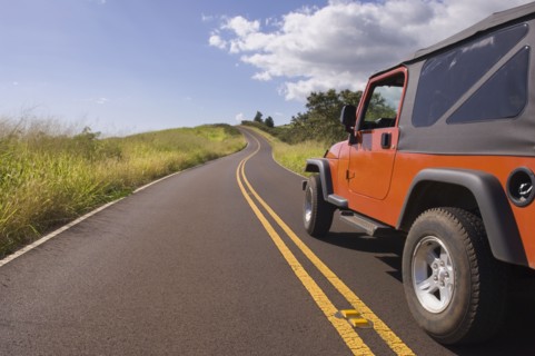 4x4 driving on remote road under blue sky