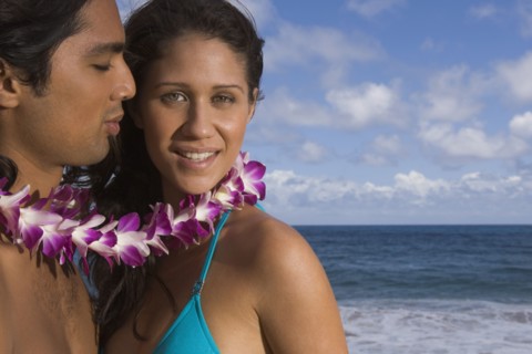 Portrait of couple wearing lei at beach