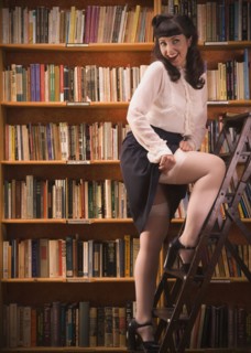 Woman in retro clothing on library ladder