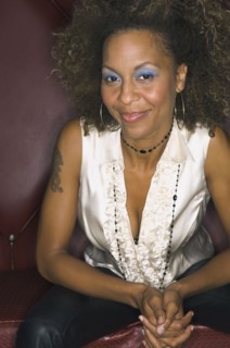 African woman sitting in cushioned booth