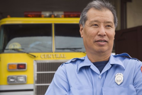 Asian male paramedic in front of ambulance