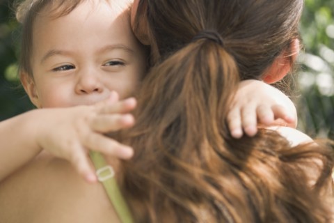 Hispanic baby hugging mother