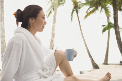 Asian woman in bathrobe holding mug