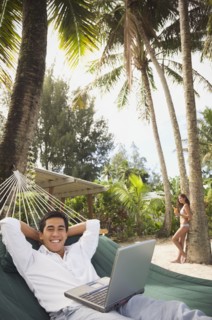 Asian man with laptop in hammock
