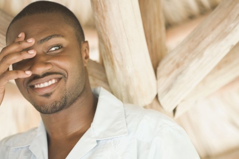 African American man with hand covering eye
