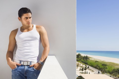 Hispanic man leaning on balcony wall