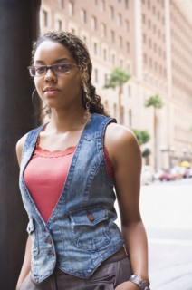 African woman leaning on street post