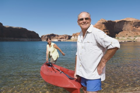 Multi-ethnic senior couple carrying kayak