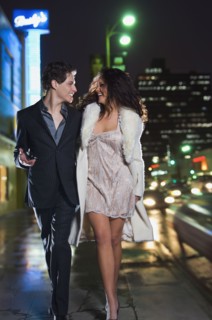 Multi-ethnic couple in formal attire walking down sidewalk